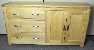 A modern oak sideboard with three drawers to one side and a cupboard with two doors to the other,