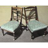 A pair of mahogany nursing chairs, on original ceramic castors,