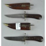 Two vintage daggers with carved wooden sheaths and handles,