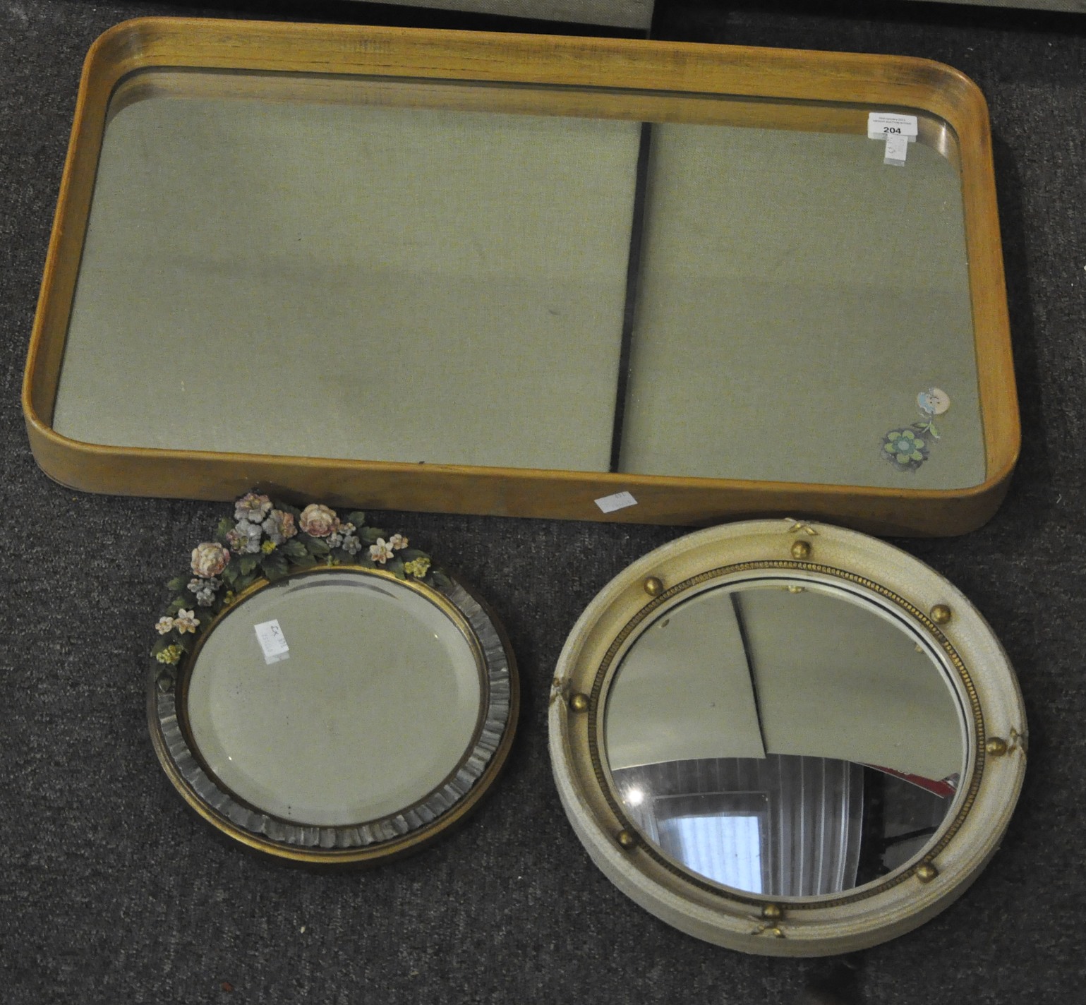 A group of three wall mirrors, including convex porthole mirror,