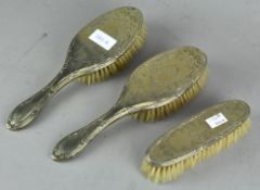 A set of three silver plate dressing table brushes,