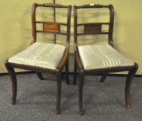 Two mahogany Regency style sabre leg dining chairs with tip in seats and rope twist back rails,