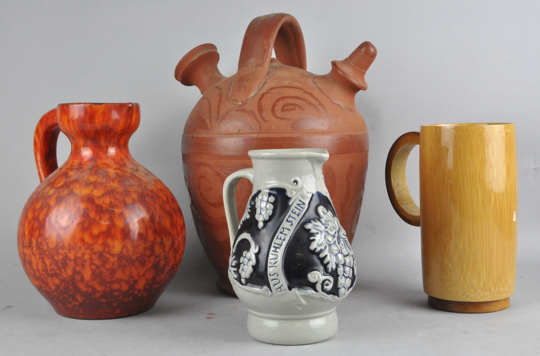 A mid-century Art pottery jug, a German jug, another jug and a wooden tankard