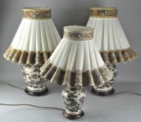 A pair of Japanese style table lamps, ceramic, and a smaller example, all with shades,