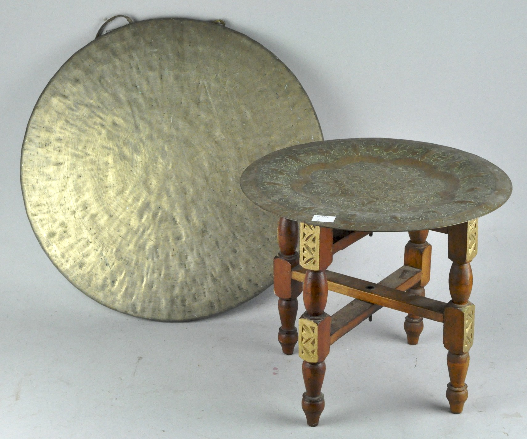 A Brass gong and a middle eastern folding brass topped tray