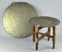 A Brass gong and a middle eastern folding brass topped tray