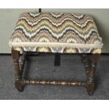 An upholstered stool on turned oak base,