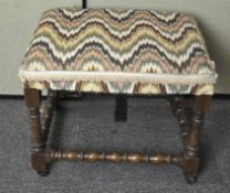 An upholstered stool on turned oak base,
