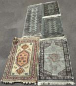 A collection of five Persian and Afghan rugs of various sizes and designs,