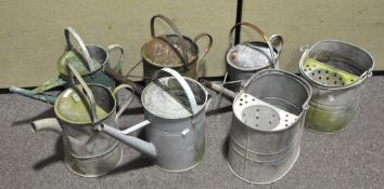 A collection of five tin watering cans,