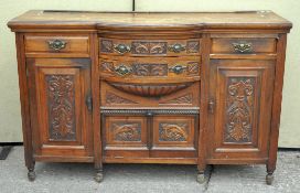 A mahogany sideboard with carved motifs to the front,