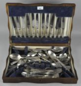 An early 20th century oak canteen containing silver plated cutlery,