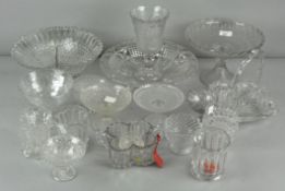 A large collection of mostly pressed glassware, including goblets, footed bowls,