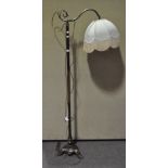 A brass standard lamp, with swan neck arm and tripod base,