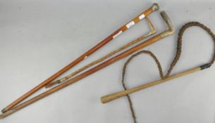 A collection of three vintage horse whips, one with antler horn handle,