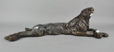 A bronzed metal figure of a reclining hare