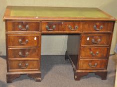 A 20th century oak twin pedestal desk, the leather top with gilt tooled border,