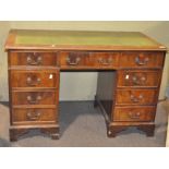 A 20th century oak twin pedestal desk, the leather top with gilt tooled border,