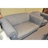 A modern grey upholstered sofa with matching armchair,