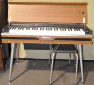 A mid 20th century teak laminate Mitsukoshi electric portable organ, raised on Dansette type legs,