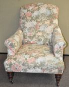 A Victorian armchair on turned legs and castors,