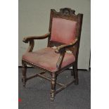 An armchair with upholstered cushion and back, each arm carved in the form of an animal's head,