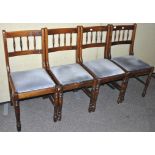 A set of four stained pine dining chairs,