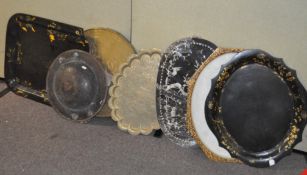 A collection of assorted trays, including papier mache examples, and a brass top for a table,