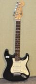 A Squire Strat guitar, lacking strings,