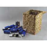 A wicker lidded basket containing a mixed assortment of items,