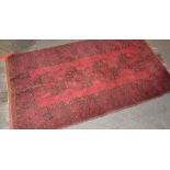 A vintage red ground rug,