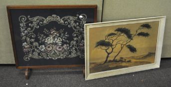 An oak framed fire screen with a floral needlework panel set to centre,