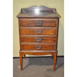 An early 20th century mahogany music cabinet, with four drawers, raised upon four feet,