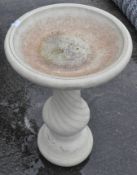 A stone bird bath on pedestal base