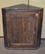 An early black painted corner cupboard,