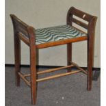 An Edwardian mahogany piano stool, with upholstered seat,