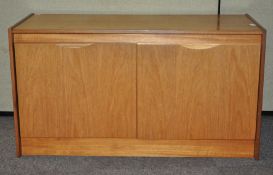A 20th century teak wood two door sideboard cupboard with shelved interior,