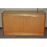 A 20th century teak wood two door sideboard cupboard with shelved interior,