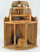 A shelved collectables corner unit with displayed items, including a hip flask,