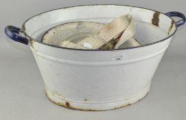 A vintage white enamel wash bowl with blue handles,