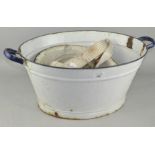 A vintage white enamel wash bowl with blue handles,