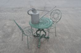 A green painted patio table and a pair of wire work chairs,