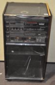 A wooden and glass Hi Fi cabinet containing Sony items, including a synthesiser,