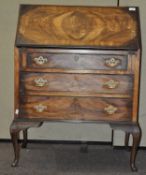 A late 19th/early 20th century walnut bureau, the opening flap with three drawers below,
