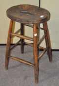 A wooden stool with saddle seat