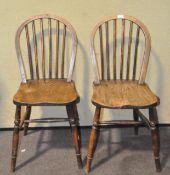 A pair of round backed oak dining chairs,