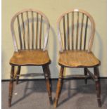 A pair of round backed oak dining chairs,