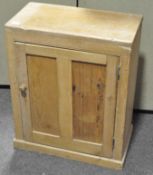 A stripped pine cupboard with a twin panelled door,