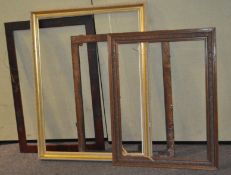 A group of four large picture frames, all wooden, one gilt,
