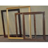 A group of four large picture frames, all wooden, one gilt,